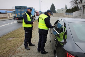 dwóch umundurowanych policjantów prowadzi przesiewową kontrolę trzeźwości