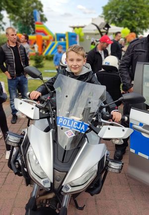 chłopiec siedzi na motocyklu policyjnym