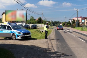 z lewej strony radiowóz, przy jezdni policjant ruchu drogowego