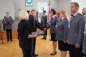 Zastępca Komendanta Wojewódzkiego Policji w Katowicach wręcza policjantce akt mianowania na wyższy stopień policyjny