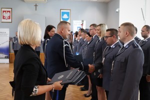 Zastępca Komendanta Wojewódzkiego Policji w Katowicach wręcza policjantowi akt mianowania na wyższy stopień policyjny