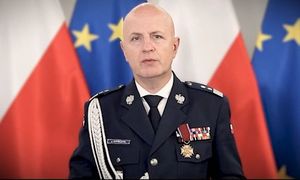 zdjęcie Komendanta Głównego Policji w mundurze galowym, na tle flag