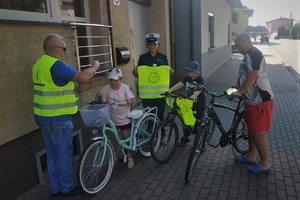 policjanci wręczają odblaski wspólnie z przedstawicielem Urzędu Gminy w Miedźnie