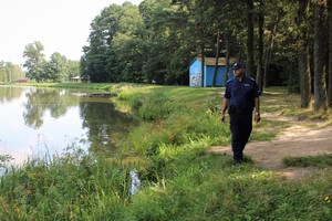 dzielnicowy idzie wzdłuż zbiornika wodnego