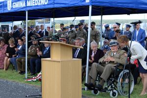 namiot gminny, pod nim ludzie siedzący na krzesłach, z prawej strony mównica