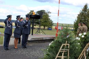 przedstawiciele służby więziennej oddający honor przed pomnikiem