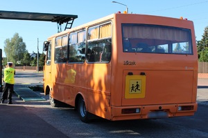 pomarańczowy autobus wjeżdżający na mobilną stację diagnostyczną