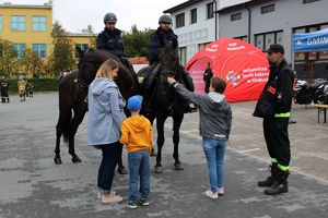 policja konna, przed nią dorośli dzieci, z prawej strony strażak