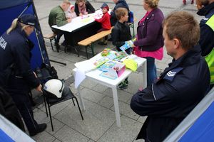 stoisko profilaktyczne policji przy nim matka z dzieckiem