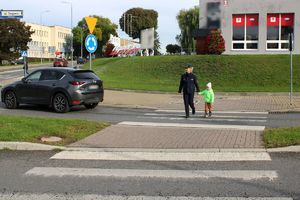 policjantka przechodzi z chłopcem przez pasy