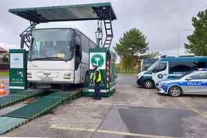 policjant kontroluje znajdujący się na mobilnej stacji autobus