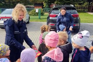 policjantka pokazuje dzieciom ulotkę