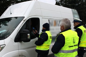 Zdjęcie przedstawia policjantów przeprowadzających badanie trzeźwości kierowcy oraz przewodniczącego GKRPA w Miedźnie.