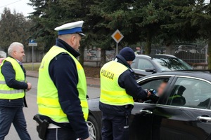 Zdjęcie przedstawia policjantów przeprowadzających badanie trzeźwości kierowcy oraz przewodniczącego GKRPA w Miedźnie.