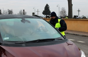 Zdjęcie przedstawia policjanta przeprowadzających badanie trzeźwości kierowcy.