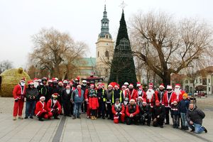 Zdjęcie przedstawia pozujących do zdjęcia policjantów i motocyklistów w czapkach i przebraniach Mikołaja.