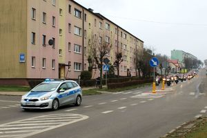 Zdjęcie przedstawia jadący radiowóz, za którym jadą motocykliści w przebraniach Mikołaja.