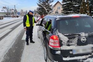 umundurowany policjant sprawdza trzeźwość kierowcy