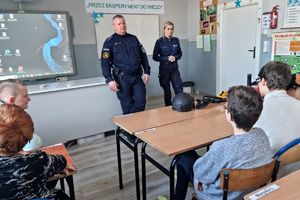 Zdjęcie przedstawia policjantkę i policjanta w klasie podczas prelekcji.