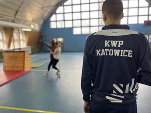 Zdjęcie przedstawia instruktora zajęć sportowych oraz mężczyznę na sali gimnastycznej.