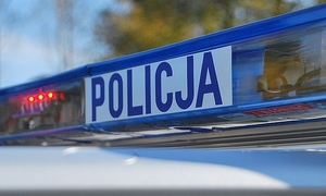 Zdjęcie przedstawia sygnalizator świetlny na dachu radiowozu z napisem Policja.