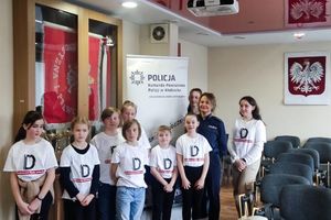 Dzieci i policjantka pozują do zdjęcia.