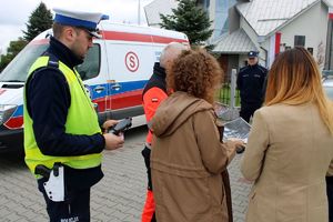 Zdjęcie przedstawia policjanta ruchu drogowego oraz kobiety, które poruszały się zatrzymanym do kontroli pojazdem osobowym.