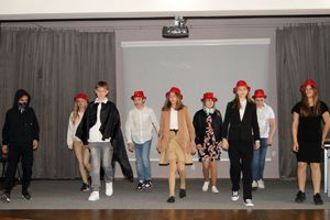 Zdjęcie przedstawia młodzieżową grupę teatralną podczas spektaklu.