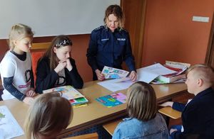 Zdjęcie przedstawia policjantkę oraz dzieci podczas obrad komisji.