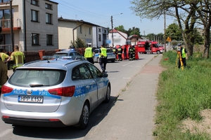 Zdjęcie przedstawia miejsce wypadku - radiowóz, policjantów oraz strażaków przy parawanie.