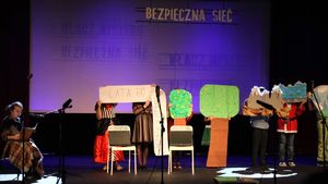 Zdjęcie przedstawia dziecięcą grupę teatralną podczas spektaklu.