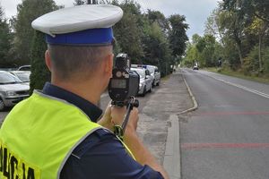 Policjant mierzy prędkość nadjeżdżającemu pojazdowi.