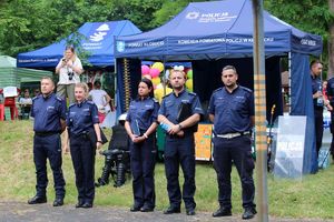 Zdjęcie przedstawia umundurowanych policjantów stojących przed policyjnym namiotem.