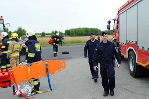 Zdjęcie przedstawia policjantów i strażaków na miejscu działań.