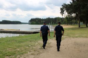 Policjanci kontrolują teren zbiornika wodnego.