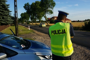 Policjant mierzy prędkość nadjeżdżającemu pojazdowi.