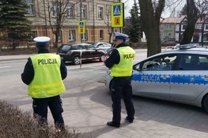 Policjanci obserwują przejście dla pieszych przed szkołą.