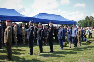 przedstawiciele służb mundurowych oddają honor stojąc na baczność