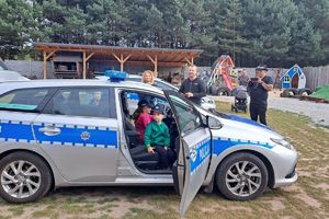 Zdjęcie przedstawia policjantki oraz dzieci w radiowozie.