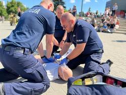 Zdjęcie przedstawia policjantów wykonujących masaż serca.