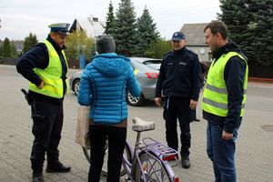 Zdjęcie przedstawia policjanta, pracownika Urzędu Gminy Miedźno oraz rowerzystę.