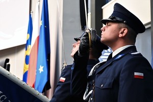 Zdjęcie przedstawia policjanta stojącego na baczność.