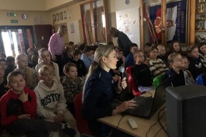 Zdjęcie przedstawia policjantkę oraz dzieci podczas prelekcji.