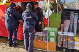 umundurowani policjanci stoją przy stoisku z fajerwerkami, prowadzą kontrolę, oglądają sprzedawane produkty