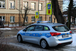 Policyjny radiowóz obok przejścia dla pieszych.