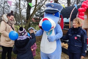 Sznupek podaje rękę dziecku, obok stoi policjantka oraz kobieta