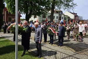 Zdjęcie przedstawia przedstawicieli służb mundurowych oraz innych uczestników uroczystości podczas składania wiązanek.