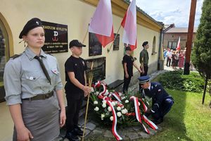 Zdjęcie przedstawia Komendanta Powiatowego Policji w Kłobucku podczas składania wiązanki pod płytą.