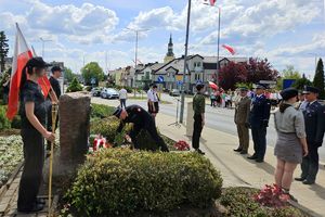 Zdjęcie przedstawia przedstawicieli służb mundurowych oraz innych uczestników uroczystości podczas składania wiązanek.