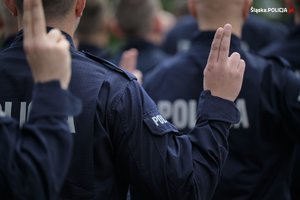 Zdjęcie przedstawia uniesione dłonie policjantów.